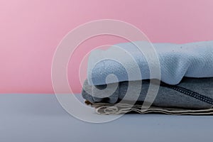 Children`s clothing after washing machine. iron clothes folded in a pile of clothing & soft pink background color. clothespins fo