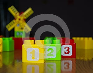 Children`s colored cubes with numbers 1-2-3 on wooden table
