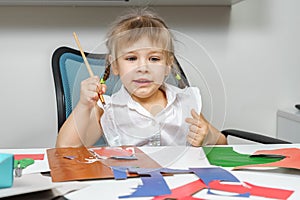 Children`s creativity. child glues colored paper