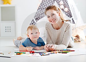 Children creativity. mother and baby son drawing together