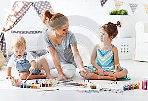 Children`s creativity. mother and children draw paints in play