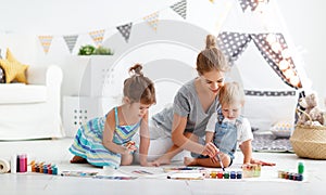 Children`s creativity. mother and children draw paints in play