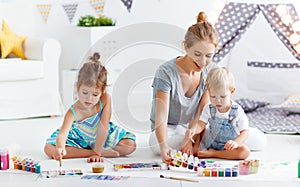 Children`s creativity. mother and children draw paints in play