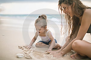 Children`s Day. Mom and baby playing near beach.