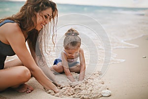 Children`s Day. Mom and baby playing near beach.