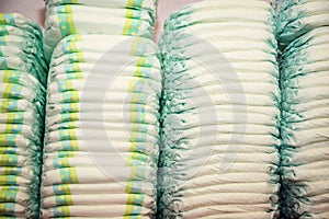 Children's diapers stacked in a many piles photo