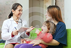 Children's doctor examining baby in home