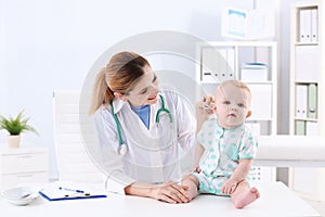 Children`s doctor examining baby`s ear