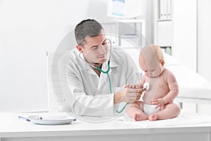 Children`s doctor examining baby with stethoscope