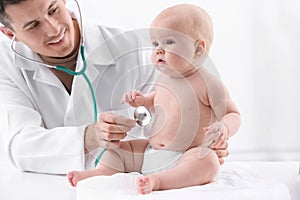 Children`s doctor examining baby with stethoscope