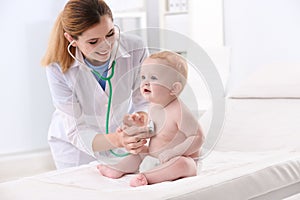 Children`s doctor examining baby with stethoscope