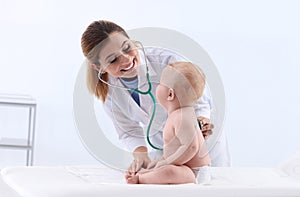 Children`s doctor examining baby with stethoscope