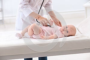 Children`s doctor examining baby with stethoscope