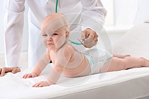 Children`s doctor examining baby with stethoscope