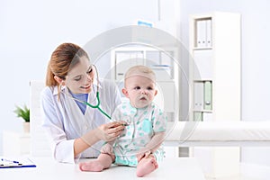 Children`s doctor examining baby with stethoscope