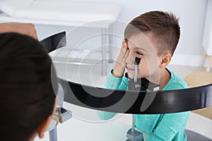 Children`s doctor examining little boy`s vision