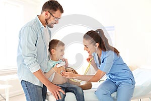 Children`s doctor examining little boy with stethoscope