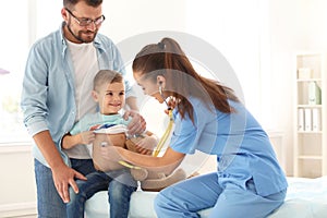 Children`s doctor examining little boy with stethoscope