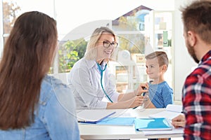 Children`s doctor examining little boy with stethoscope in hospital