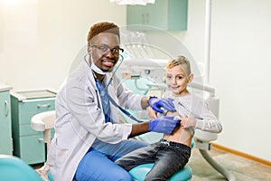 Children`s doctor examining little boy with stethoscope in hospital