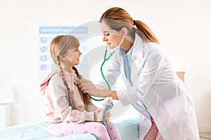 Children`s doctor examining little girl in hospital