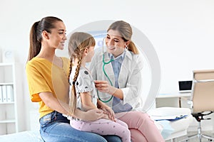 Children`s doctor examining little girl near parent