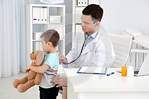 Children`s doctor examining little patient with stethoscope