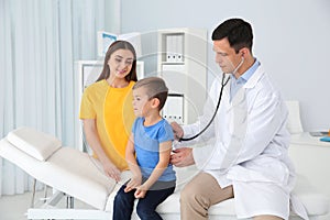 Children`s doctor examining little patient with stethoscope