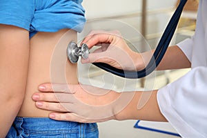 Children`s doctor examining patient with stethoscope