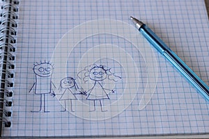 Children`s drawing of a family in a checkered notebook