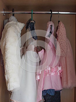 Children `s dress-up dresses on a hanger, children `s things, outfits for little ones