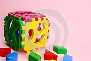 Children's educational game cube sorter on a pink background