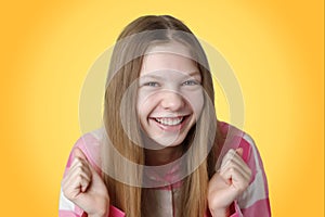 children's emotions portrait of a happy blonde girl in a pink shirt and laughing