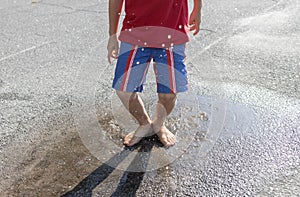 children's feet barefoot jump into puddle on the asphalt on a summer day after the rain