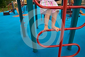 Children`s feet barefoot on the playground with obstacles. little Girls legs on the stairs