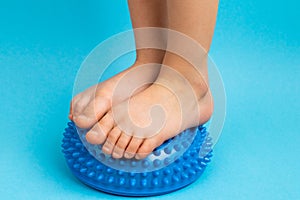 children& x27;s feet with a blue balancer on a light blue background, treatment and prevention of flat feet, valgus