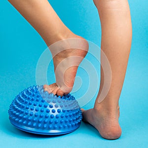 children& x27;s feet with a blue balancer on a light blue background, treatment and prevention of flat feet, valgus