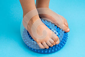 children& x27;s feet with a blue balancer on a light blue background, treatment and prevention of flat feet, valgus