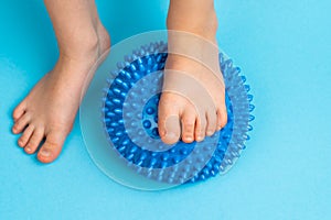 children& x27;s feet with a blue balancer on a light blue background, treatment and prevention of flat feet, valgus