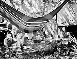 Children's feet in blue hammock on a background of the nature gr