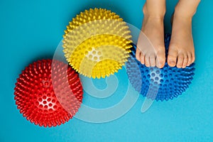 children's feet with a colored balancer on a light blue background, treatment and prevention of flat feet, valgus