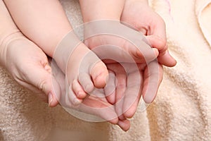 Children's feet in the hands of the mother