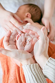 Children`s feet in hands of mother and father. Mother, father and Child. Happy Family concept