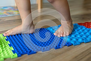 children's feet, massage mats with different textures for foot massage, .Exercises for legs orthopedic massage carpet