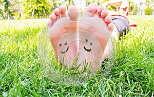 Children`s feet with a pattern of paints smile on the green grass. Selective focus