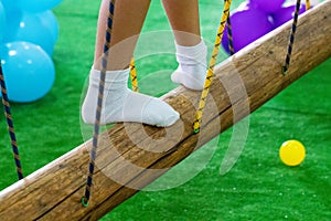 Children`s feet at the playground with swinging bridge