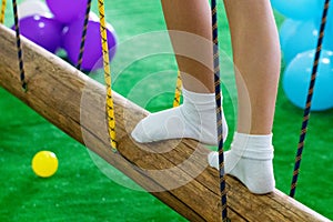 Children`s feet at the playground with swinging bridge