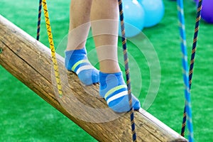 Children`s feet at the playground with swinging bridge