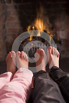 Children's feet warming at a fireplace