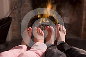 Children's feet warming at a fireplace